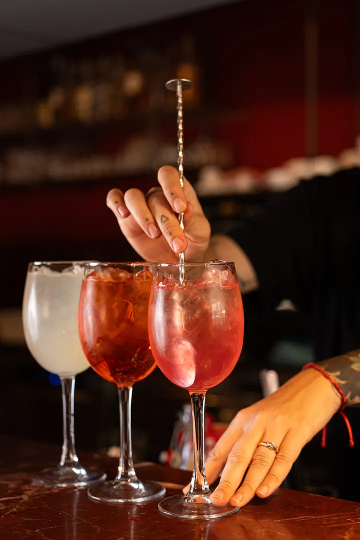 调酒师在 L'Angolo di Cavour 的红色大理石吧台上调制 spritz，维罗纳